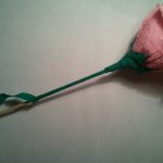 Далее отрежьте две тонких полоски (высотой 1 см) зеленой гофры. Затем медленно, начиная от чашелистика, обмотайте ствол будущей розы.