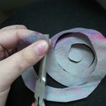 Закрепляется цветок горячим клеевым пистолетом, покрывая поверхность слоем клея с обратной стороны.